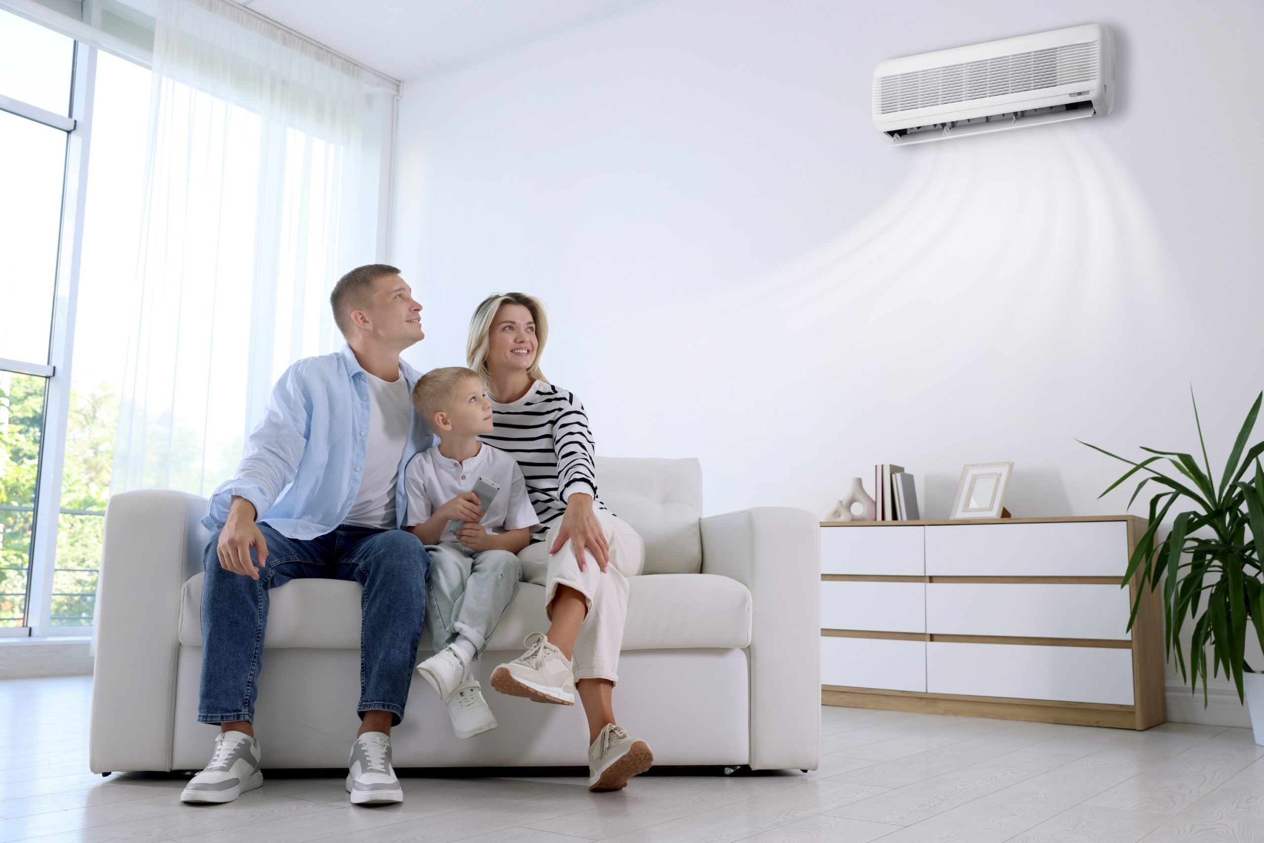Family relaxing on a couch beneath a wall-mounted ductless mini split