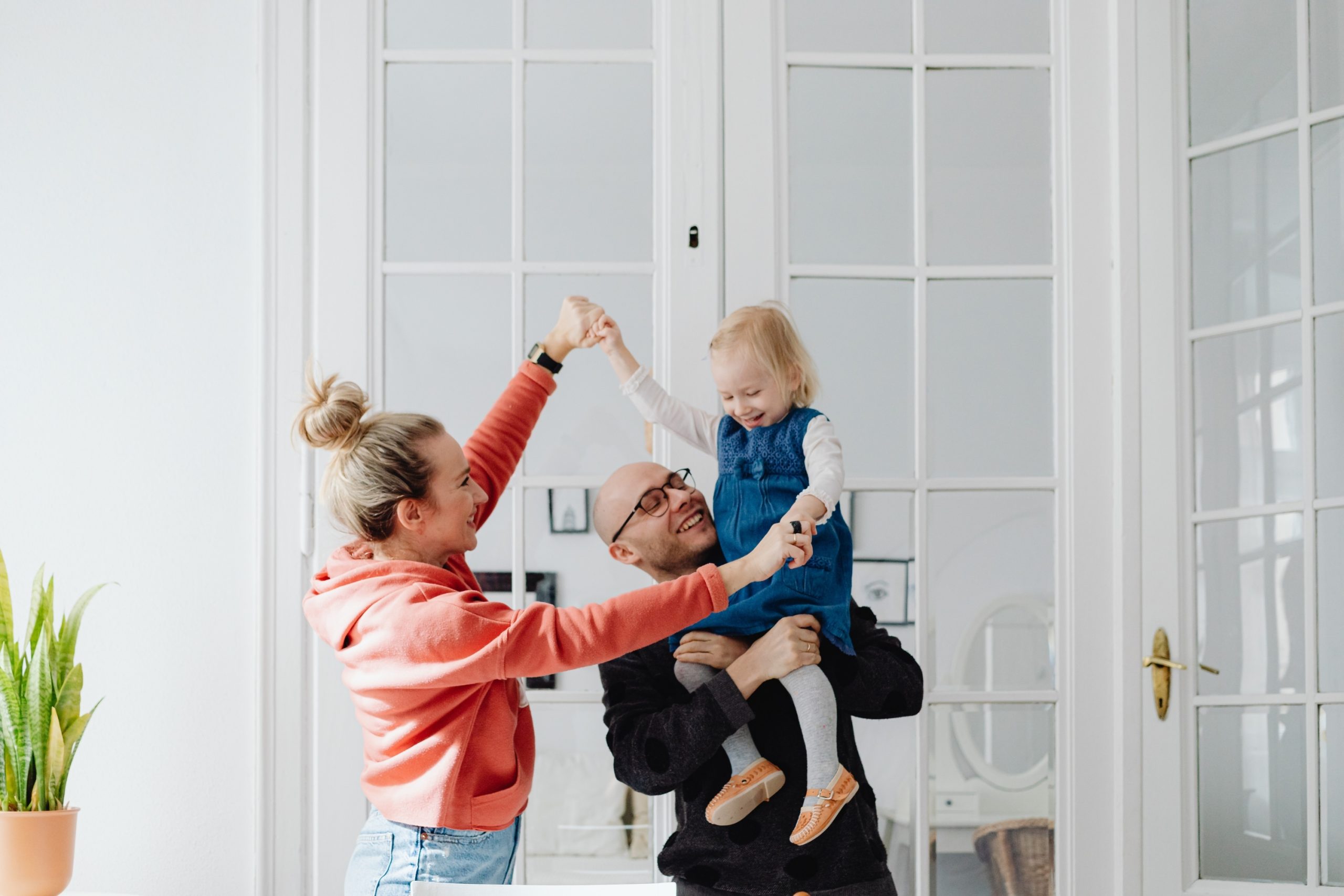 Parents lifting their toddler in a comfortable air-conditioned home
