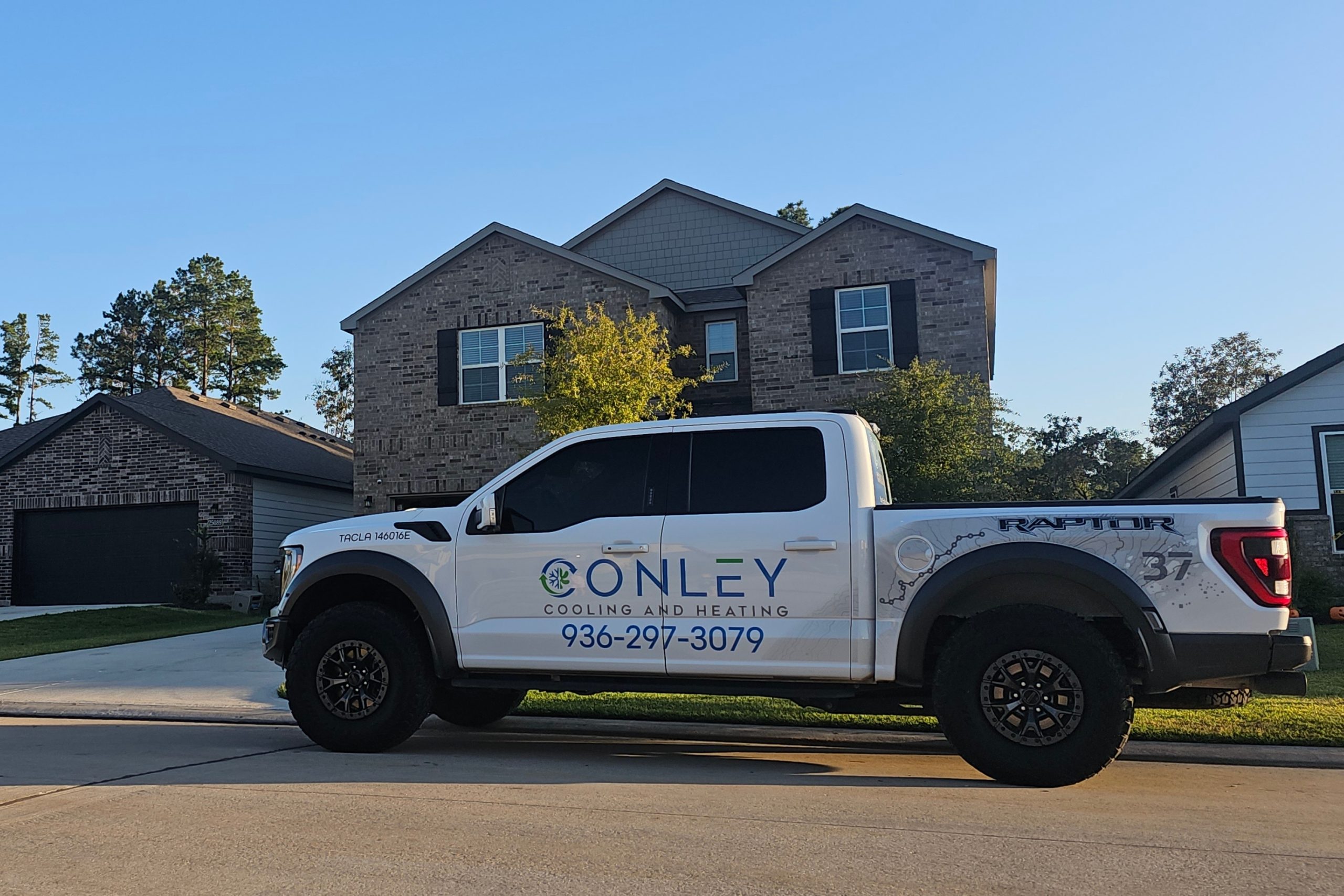 Conley Cooling and Heating service truck parked outside a two-story brick home