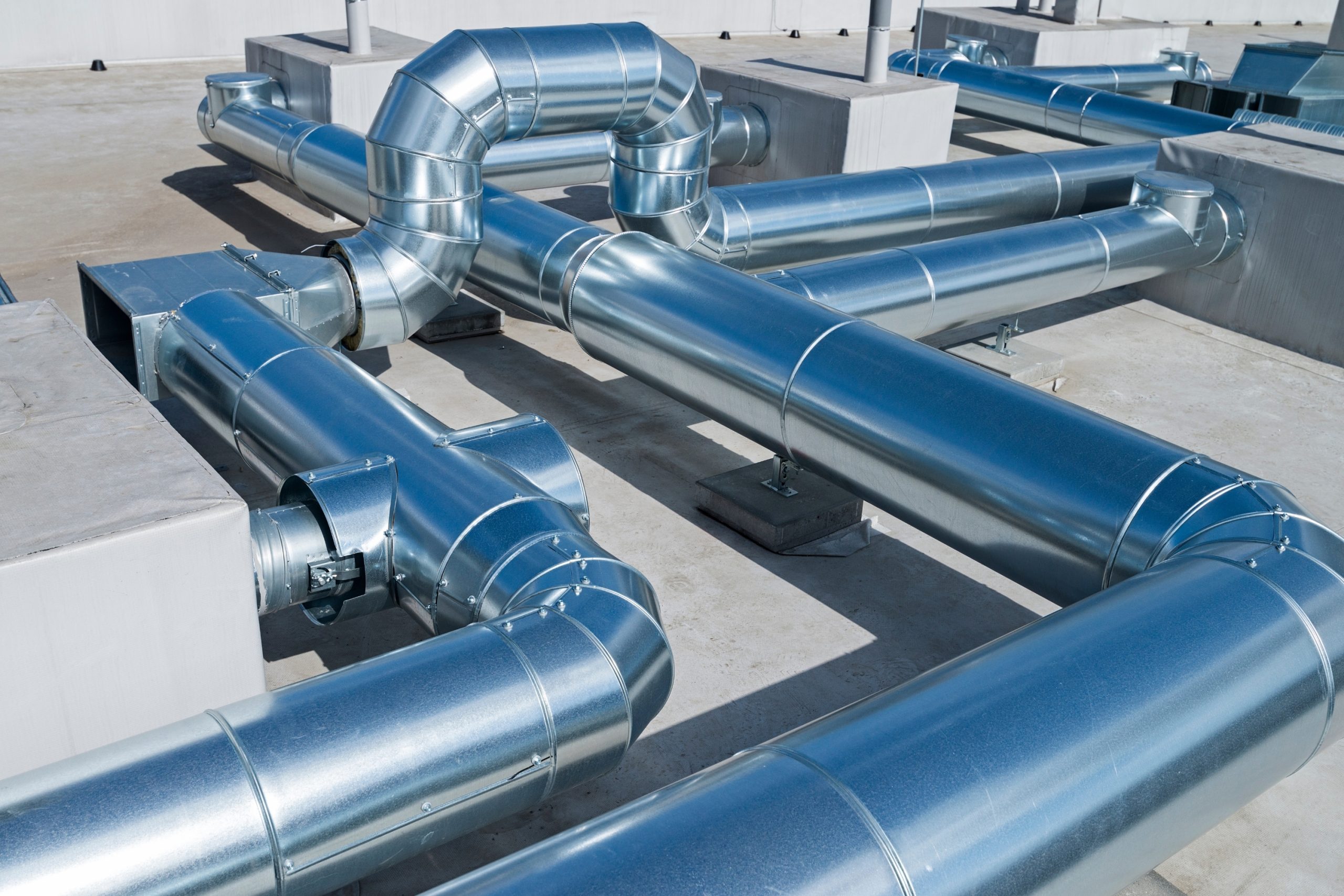 Large galvanized spiral duct trunk lines in a commercial mechanical room